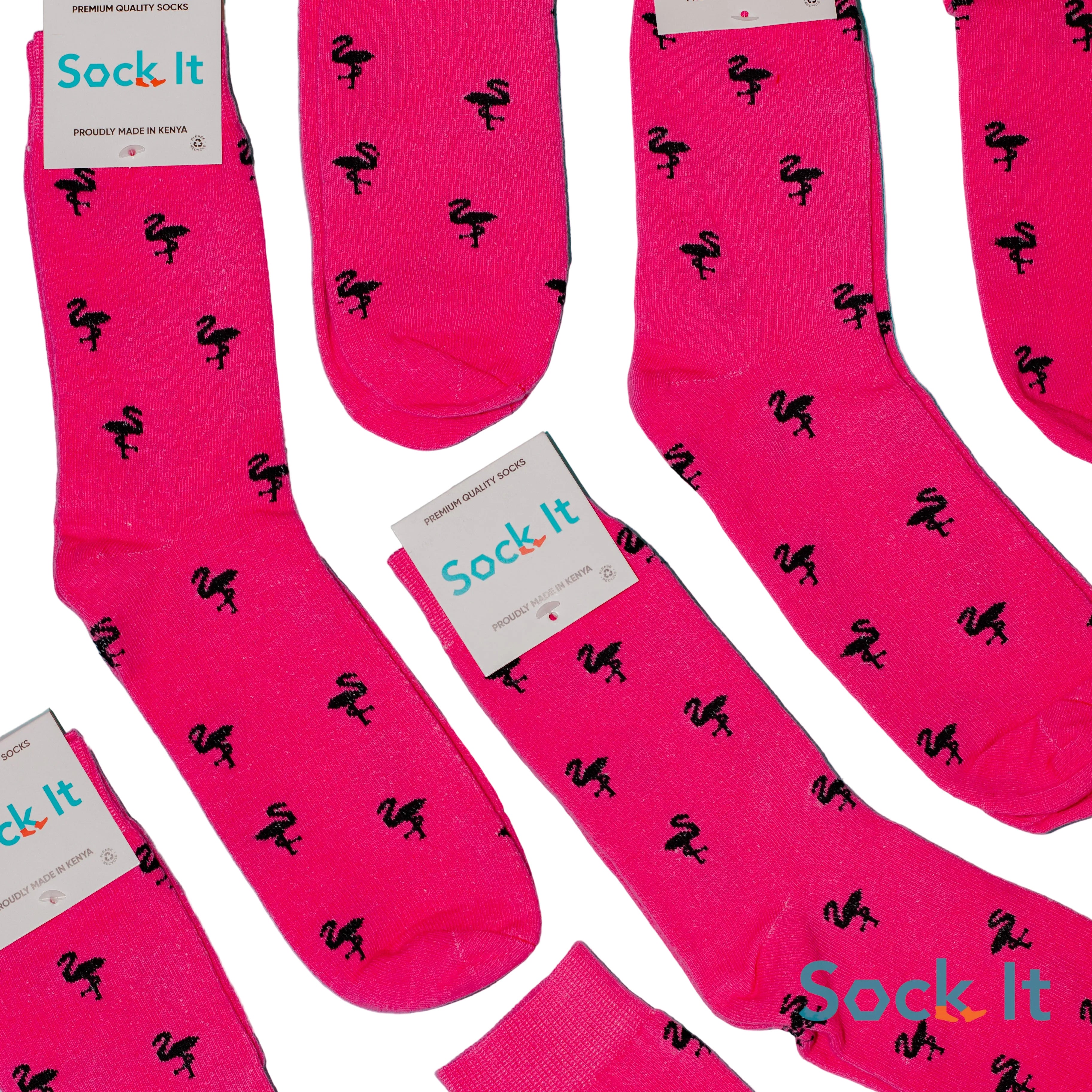Pink socks with black flamingo pattern and 'Sock It' branding on a blue background
